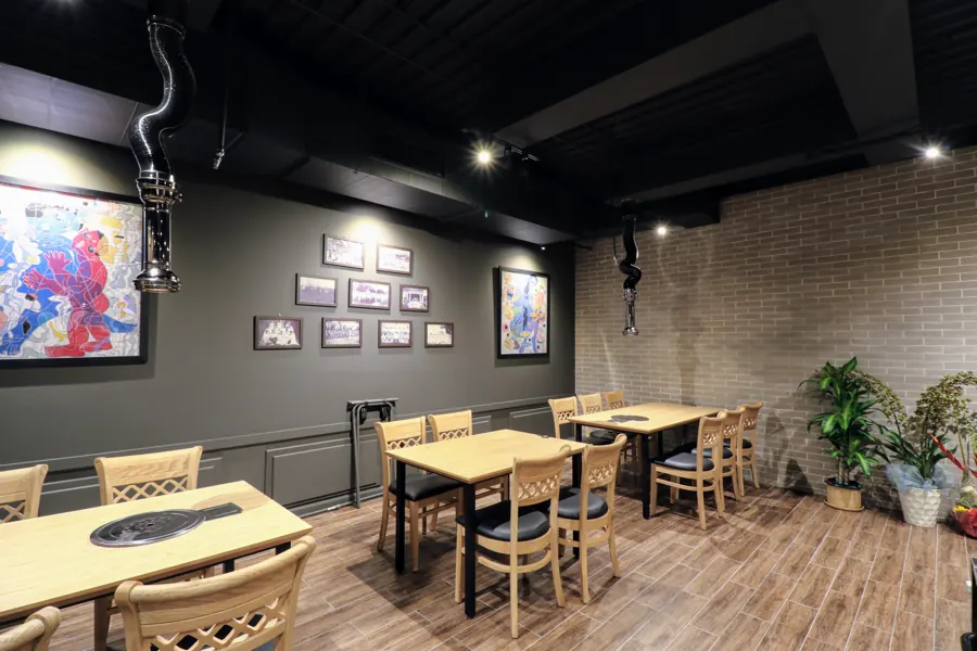 Dining room with paintings on a dark wall